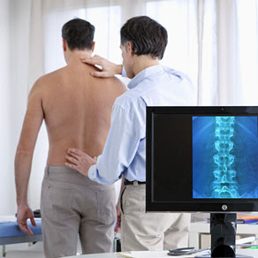 doctor examining patient's spine with x-ray